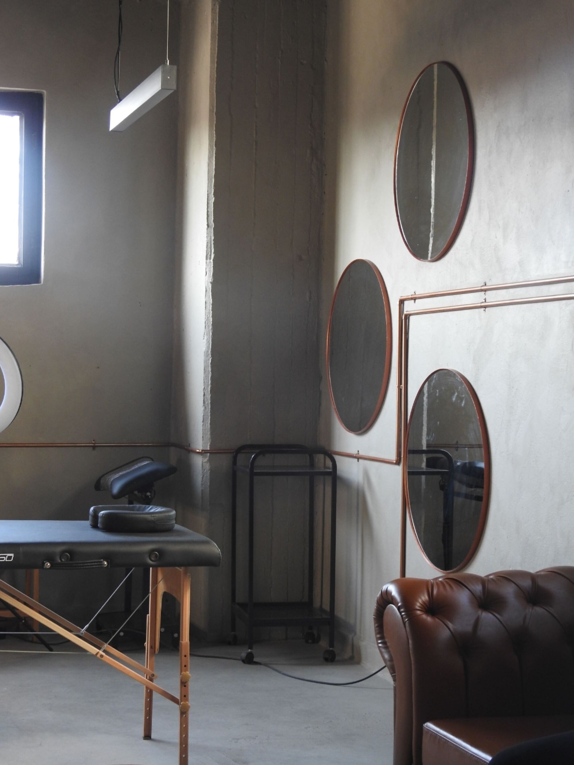 A serene wellness therapy space with copper circular mirrors